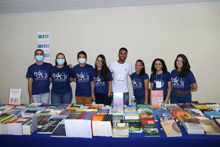 Equipe reunida junto à exposição de livros da FLI 2022